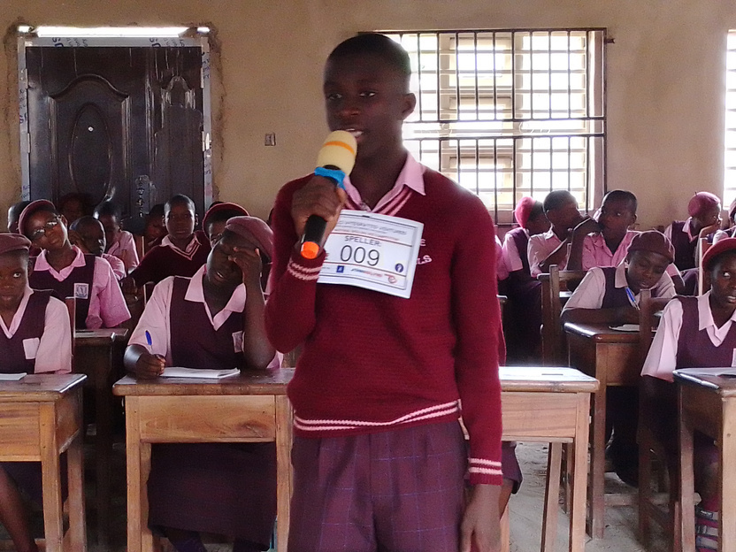Student spelling into a microphone during a KCI school event